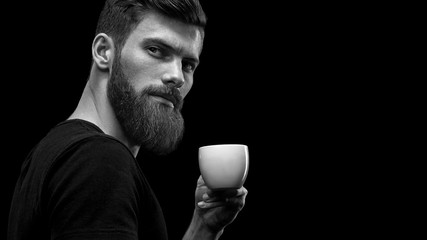 Bearded stylish man in black with cup of coffee