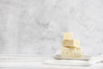 Sliced feta cheese on light background. High key. With copy space