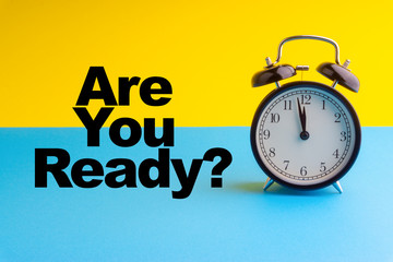 ARE YOUR READY inscription written and Alarm Clock on blue yellow background. Business and motivation concept