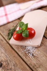  fresh tomatoes with basil and salt on a rustic wooden table - healthy breakfast 