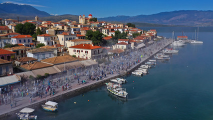 Fototapeta na wymiar Aerial drone bird's eye view photo of people participating in traditional colourful flour war or Alevromoutzouromata part of Carnival festivities in historic port of Galaxidi, Fokida, Greece