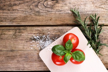  fresh tomatoes with basil and salt on a rustic wooden table - healthy breakfast 