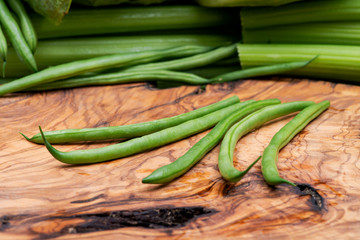 Fresh Raw Organic French Green Beans (Haricot Verts), or Filet Beans on natural olive wood.