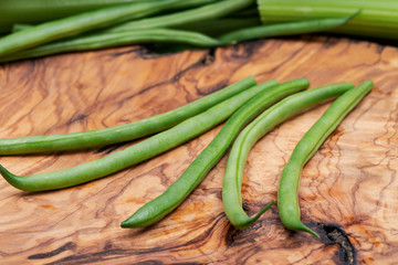 Fresh Raw Organic French Green Beans (Haricot Verts), or Filet Beans on natural olive wood.