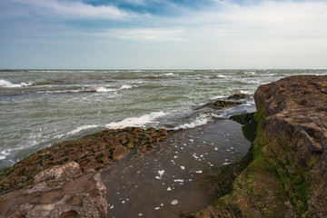 Fototapeta na wymiar Surf on a rocky sea coast landscape