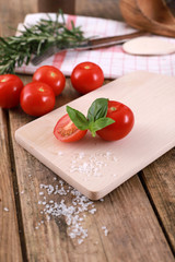  fresh tomatoes with basil and salt on a rustic wooden table - healthy breakfast 
