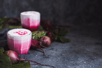 Beetroot latte. Healthy beetroot drink with whole beetroots on dark background with copy space. 