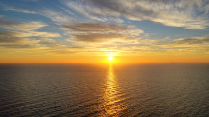 Aerial drone panoramic photo of beautiful sunset over the Aegean sea with golden colours, Greece