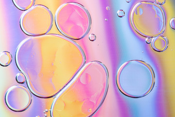 Beautiful macro photo of water droplets in oil with a colorful background.