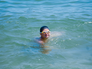 Young fat child swimming at sea, concept of overweight 