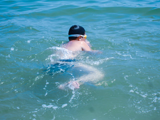 Young fat child swimming at sea, concept of overweight 