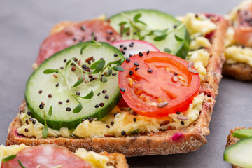 Sandwiches with cream cheese, vegetables and salami.