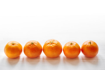 Tangerine fruits on a white wooden table