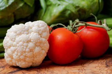 A variety of fresh raw Organic Vegetables including Cauliflower and Tomatoes on the vine.