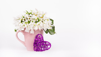 Spring flowers and wicker heart. Copy space.