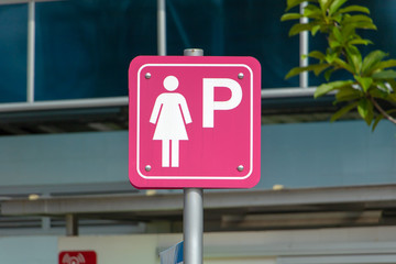 Parking place only for women. Lady parking sign on the street. A traffic pink color sign for female drivers to park their cars.