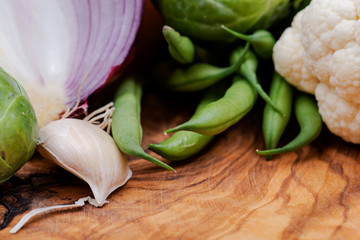 A variety of fresh raw Organic Vegetables including Red Onion, Garlic, French Green Beans, Cauliflower.