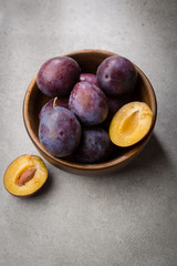 Fresh plums in wooden bowl