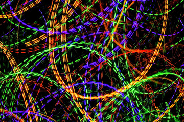 The chaotic lines of color lights on dark background. Colorful lights is move in the black space.