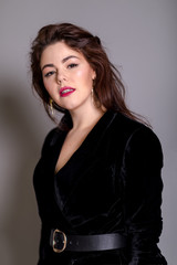 Fototapeta na wymiar Beautiful elegant sexy brunette diva woman portrait in black clothes on grey background