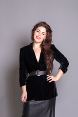 Beautiful elegant sexy brunette diva woman portrait in black clothes on grey background