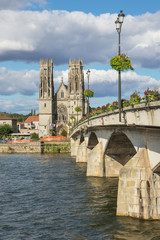 Fototapeta premium The Moselle in Pont-a-Mousson with the bridge over the river with Saint Martin's church in the background