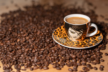 espresso cup with roasted coffee beans on a wooden table