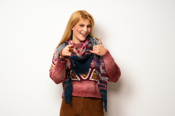 Hippie woman over white wall making phone gesture and pointing front