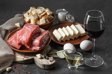 Fresh raw meat, eggs, butter on black wooden table