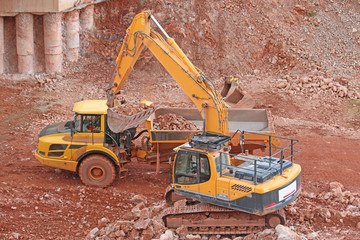 Obraz premium digger loading a dump truck on a road construction site