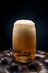 glass of beer with foam on black background