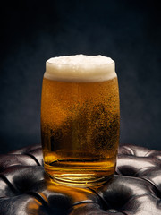 glass of beer with foam on black background