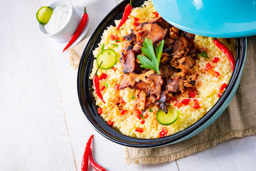 Tajin with couscous, vegetables and meat on white background