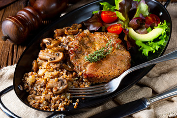 Pork steak with mushrooms and buckwheat groats and mango salad