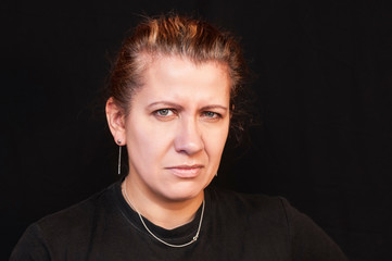 Obraz premium Portrait of beautiful woman on black background. A woman has a sad face because her hair begins to become gray