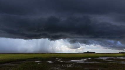 Dark storm and rain over salt water marsh