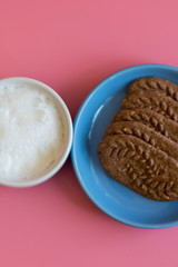 cup of cappuccino, cookies with chocolate. coffee cup with cookie for breakfast morning. On a pink background. vertical photo. copy space