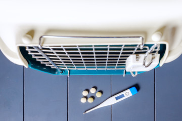 Carrier for a pet with a medical thermometer and pills. Concept of veterinary clinic and first aid for cats and dogs