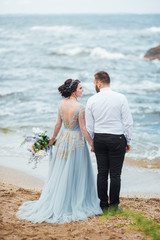 same couple with a bride in a blue dress walk