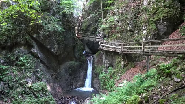 Kleiner Wasserfall in einer Klamm mit befestigten Steg