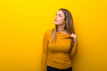 Obraz premium Young woman on yellow background with tired and sick expression