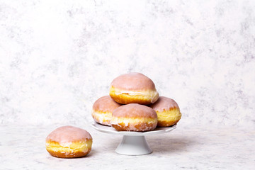 Traditional Polish donuts with frostng on light background. Tasty doughnuts with jam.