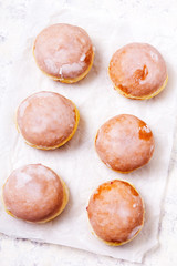 Traditional Polish donuts with frostng on light background. Tasty doughnuts with jam.