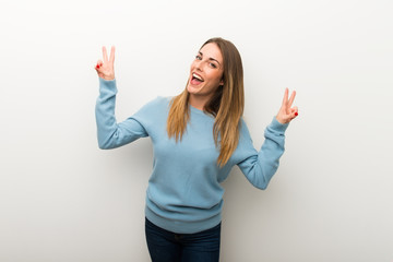 Blonde woman on isolated white background smiling and showing victory sign with both hands