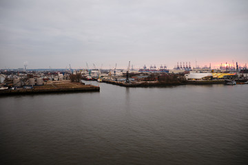 Hamburg Harbor with beautiful sunset and loading cranes