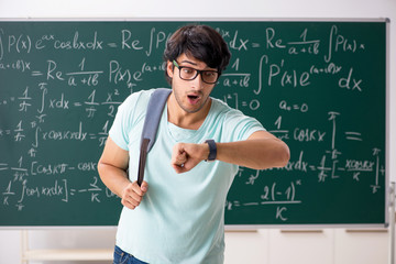 Young male student mathematician in front of chalkboard 