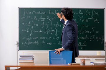 Young male math teacher in classroom 