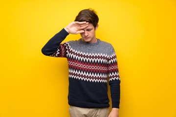 Teenager man over yellow wall with tired and sick expression