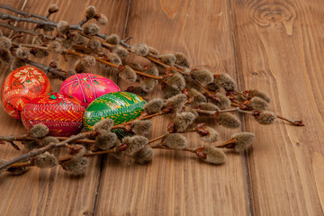 Still life with Pysanka, decorated Easter eggs, dry willow branches on black wooden background, top view, copy space