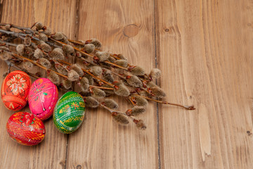 Still life with Pysanka, decorated Easter eggs, dry willow branches on black wooden background, top view, copy space